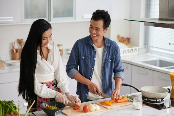 Šťastný Mladý Asijský Pár Chatování Při Stání Kuchyňského Stolu Vaření — Stock fotografie