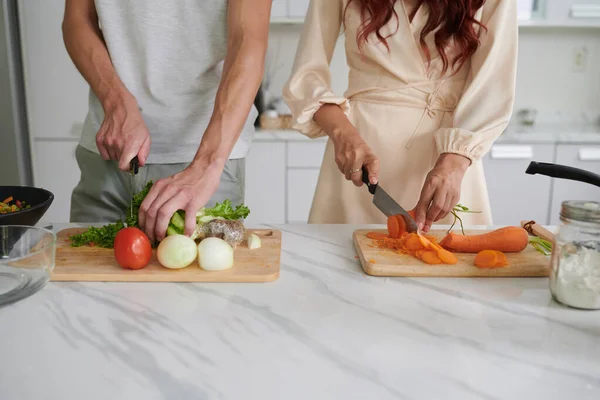 年轻异性夫妇在准备素食沙拉时用刀切新鲜蔬菜的切碎照片 — 图库照片