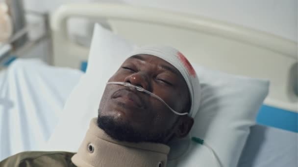 Κοντινό Πλάνο Του Αφροαμερικανού Τραυματία Επίδεσμο Στο Κεφάλι Ξαπλωμένος Στο — Αρχείο Βίντεο