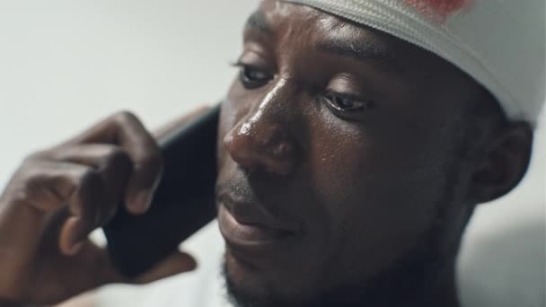 Zbliżenie Afroamerykańskiego Żołnierza Krwawiącą Raną Głowy Rozmawiającego Przez Telefon Przyjacielem — Wideo stockowe