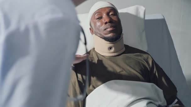 현대군 병원에서 침대에 머리에 상처를 가운을 군인을 지원하는 — 비디오
