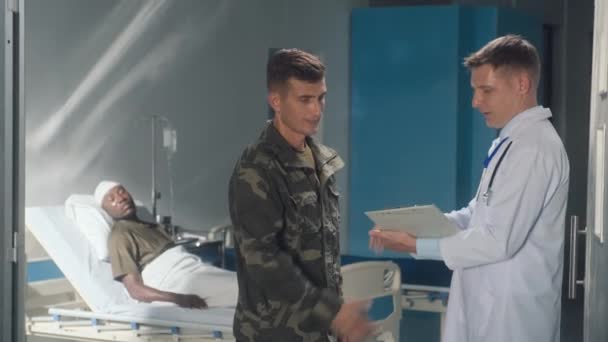 Żołnierz Mundurze Ściskający Dłonie Dziękujący Lekarzowi Mówiący Stanie Zdrowia Pacjenta — Wideo stockowe