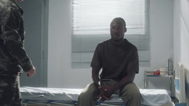 军人医院巡诊期间 身着军服的支持朋友坐在病房里的中弹士兵 — 图库视频影像