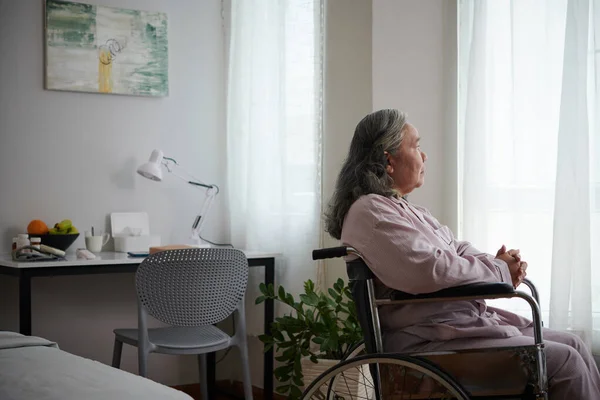 Sjuk Äldre Kvinna Sitter Rullstol Och Tittar Genom Fönstret — Stockfoto
