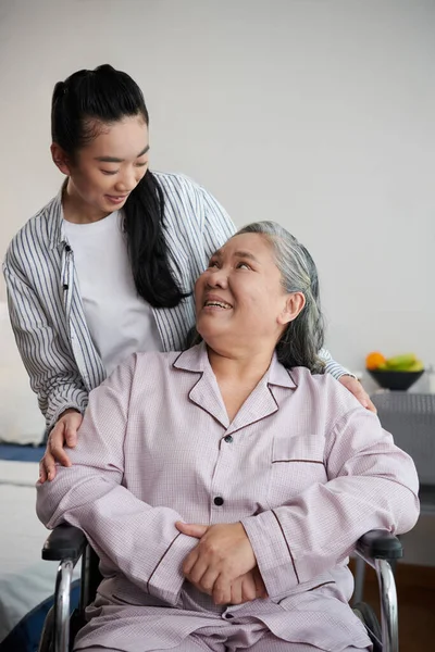 車椅子に座っている老人ホームの患者と話す介護者 — ストック写真