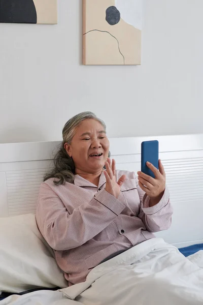 Mujer Mayor Sonriente Sentada Cama Video Llamando Amigos Familiares Memeber — Foto de Stock