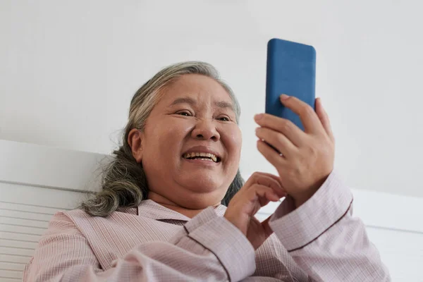 陽気な高齢女性笑います上のミーム上のソーシャルメディア — ストック写真