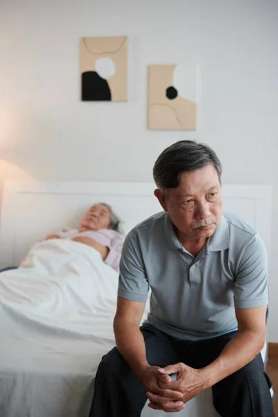 Endişeli Kıdemli Adam Hasta Karısının Yatağında Oturuyor — Stok fotoğraf