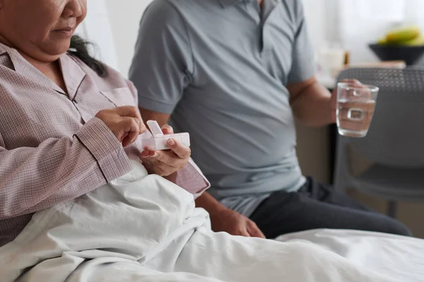 Starsza Kobieta Bierze Tabletki Mąż Przynosi Jej Kubek Wody — Zdjęcie stockowe