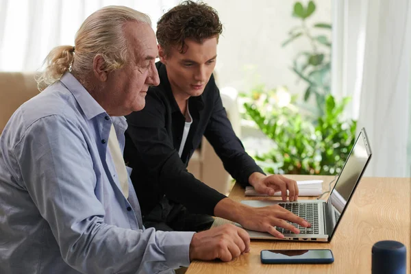 Young Man Helping Grandfather Installing New Application Laptop — Stock Photo, Image