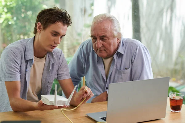 Jovem Definindo Roteador Para Estabelecer Conexão Com Internet Para Avô — Fotografia de Stock