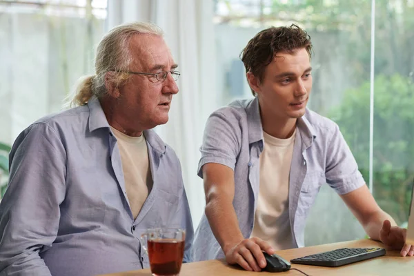 Νεαρός Που Δείχνει Στον Παππού Πώς Αναζητήσει Πληροφορίες Στο Διαδίκτυο — Φωτογραφία Αρχείου
