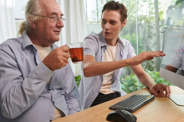 Jovem Alegre Mostrando Avô Como Comprar Bilhete Simples Online — Fotografia de Stock