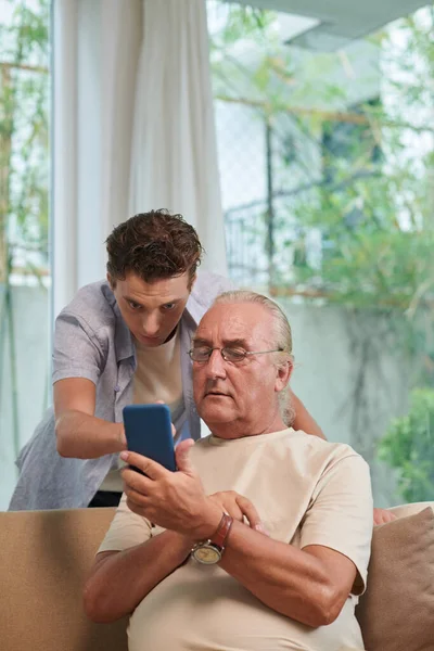 Starší Muž Žádá Vnuka Aby Pomohl Mobilní Aplikací Smartphone — Stock fotografie