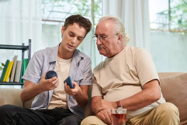 Jovem Explicando Avô Como Conectar Smartphone Com Alto Falante — Fotografia de Stock