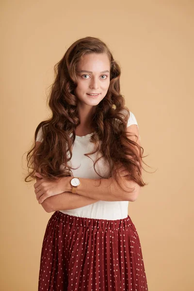 Açık Kahverengi Kıvırcık Saçlı Kollarını Kavuşturup Kameraya Bakan Gülümseyen Kızın — Stok fotoğraf