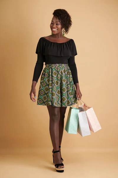 Gülümseyen Siyah Kadın Alışveriş Torbalarıyla Yürüyor Uzaklara Bakıyor — Stok fotoğraf
