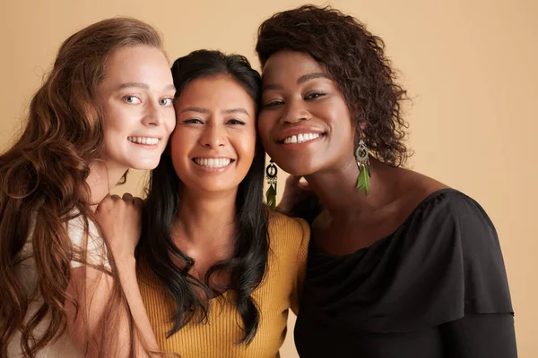 Diverse Groep Van Glimlachende Vrouwelijke Vrienden Knuffelen Tegen Beige Achtergrond — Stockfoto