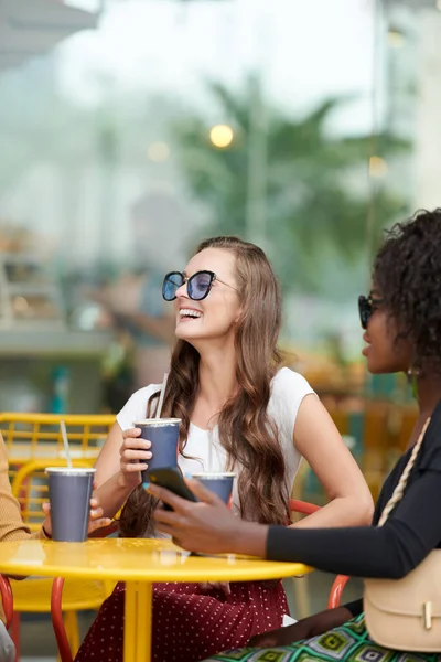 Szczęśliwa Młoda Kobieta Okularach Przeciwsłonecznych Spędzająca Czas Przyjaciółmi Rozmawiająca Pijąca — Zdjęcie stockowe