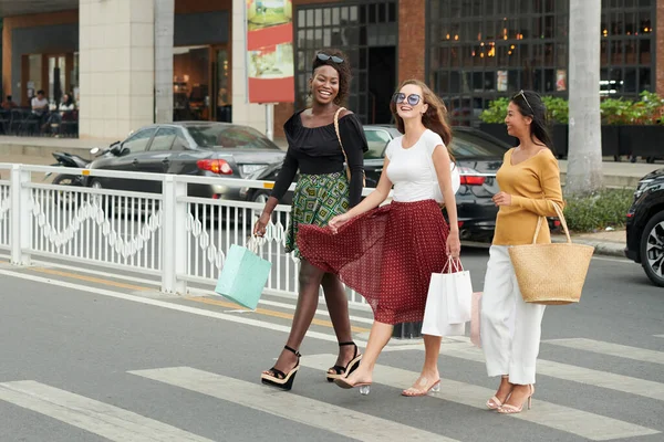 Jovens Mulheres Elegantes Felizes Carregando Sacos Compras Cruzar Estrada Movimentada — Fotografia de Stock