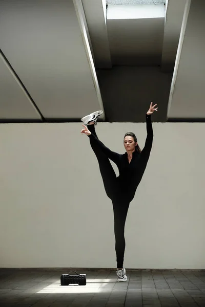Стройная Молодая Женщина Черном Комбинезоне Танцует Музыку Динамике — стоковое фото