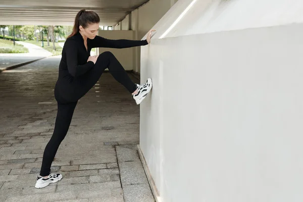 Fit Junge Frau Legt Bein Wand Sich Nach Dem Training — Stockfoto