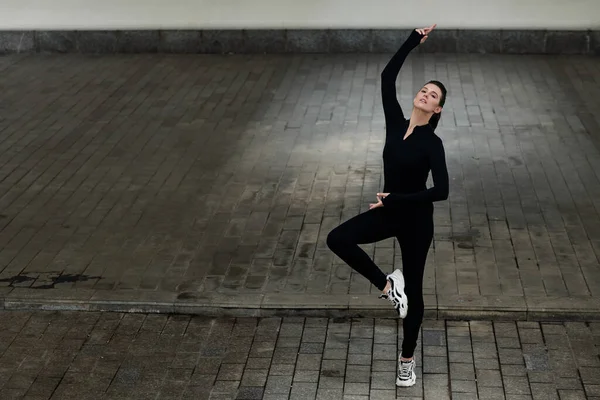 穿着黑色紧身衣的年轻女舞蹈家喜欢在户外表演 — 图库照片