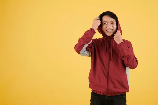 Szczęśliwy Podekscytowany Młody Człowiek Zakładając Kaptur Utwór Jacked Odizolowany Żółty — Zdjęcie stockowe