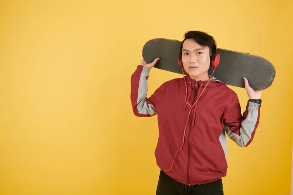 Portret Van Een Jongeman Die Skateboard Vasthoudt Naar Muziek Luistert — Stockfoto
