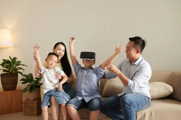 支持快乐男孩在虚拟现实游戏中获胜的兴奋家庭 — 图库照片