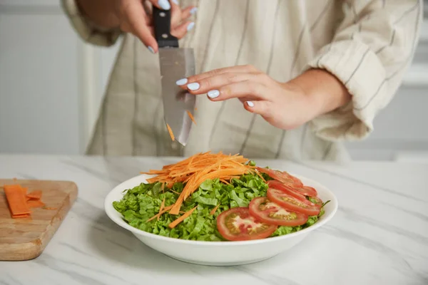 Vrouw Toevoegen Gesneden Wortelen Top Salade Kom — Stockfoto