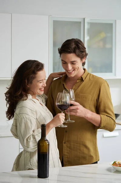 ディナーの前に赤ワインを楽しむ愛の喜び若いカップル — ストック写真