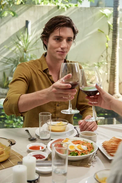 Νεαρός Άντρας Κοιτάζει Φίλη Του Όταν Κάνει Πρόποση Ποτήρι Κρασιού — Φωτογραφία Αρχείου
