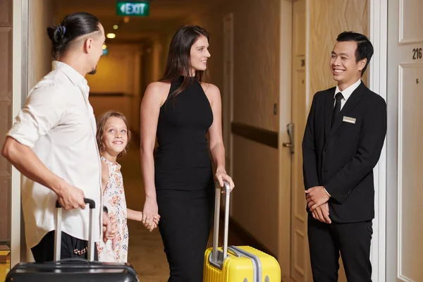 Sorrindo Recepcionista Hotel Mostrando Família Feliz Com Malas Seu Quarto — Fotografia de Stock