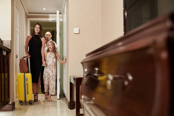 興奮した十代の女の子と彼女の両親がホテルの部屋に入る — ストック写真