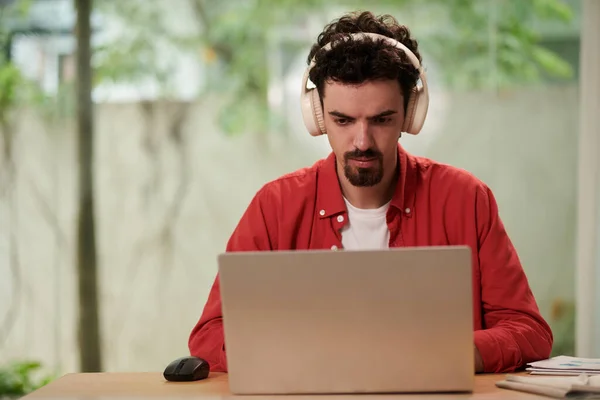 Evde Dizüstü Bilgisayarda Çalışırken Kulaklık Takan Programcı — Stok fotoğraf
