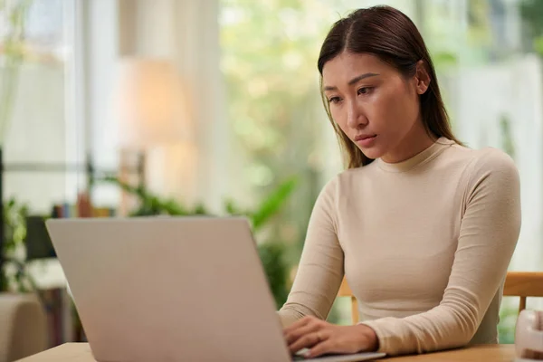 Allvarlig Ung Kvinna Beige Polotröja Arbetar Laptop Hemma — Stockfoto