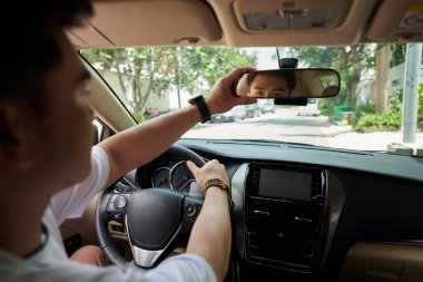 Şehir caddesinde işe giderken şoför dikiz aynasını ayarlıyor