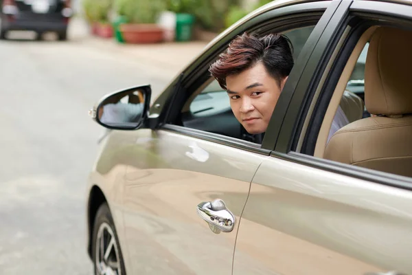 Młody Człowiek Spoglądający Przez Okno Podczas Parkowania Przed Domem — Zdjęcie stockowe