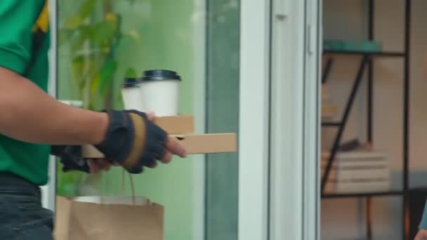 送货员戴着手套在门阶上给女客户咖啡和午餐的剪影 — 图库视频影像