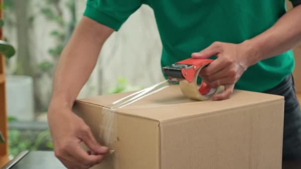 Ofisteki Müşteriye Göndermeden Önce Posta Işçisinin Karton Kutuyu Mühürlerken Yakın — Stok video
