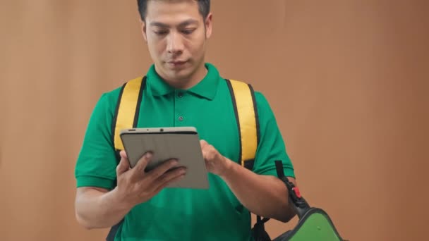 Retrato Mensajero Uniforme Verde Con Bolsa Amarilla Casco Usando Tableta — Vídeos de Stock