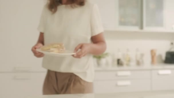 在厨房吃早餐的时候 年轻妈妈给孩子吃煎饼和果汁 — 图库视频影像
