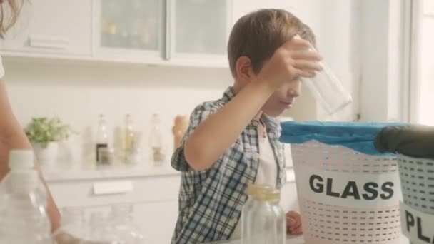 Junge Trennt Gemeinsam Mit Mama Der Küche Müll Mit Glas — Stockvideo