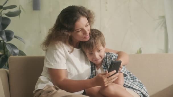 Anne Oğul Evde Oturup Akıllı Telefondan Fotoğraf Izliyorlar Oturma Odasında — Stok video