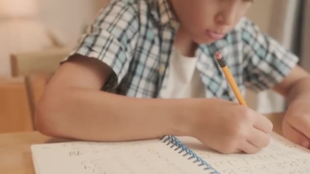 专心致志地训练男孩独自坐在桌旁写英文字母 — 图库视频影像
