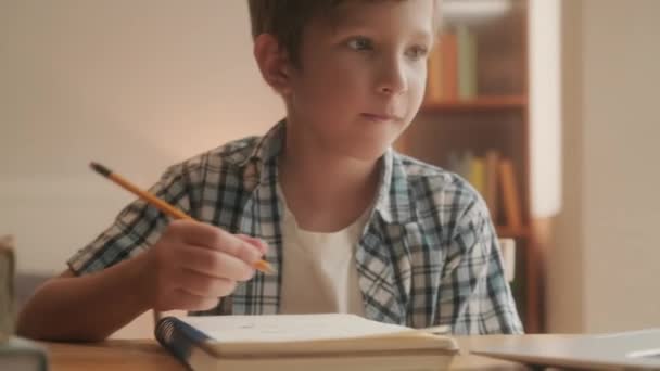 Średnie Ujęcie Chłopca Wieku Przedszkolnym Odrabiającego Lekcje Copybooku Przy Użyciu — Wideo stockowe