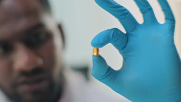 用医用手套手拿着药丸的科学家的近视及其在实验室中的应用 — 图库视频影像