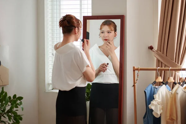 鏡のワインの前に赤い口紅を適用するトランスジェンダーの女性は仕事のために準備を取得 — ストック写真