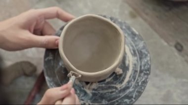 Çömlek tekerindeki özel aletle el şekillendirme kil çömleğinin yüksek açılı görüntüsü